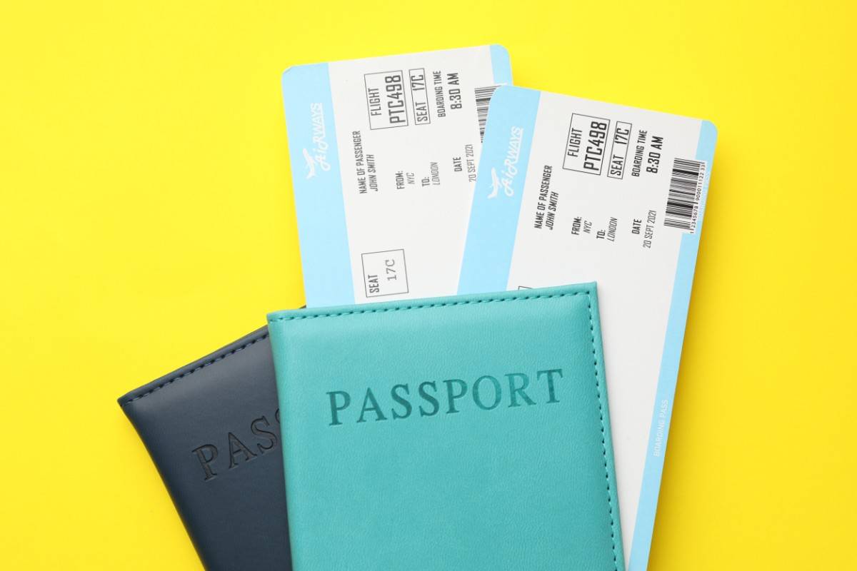 Flight Tickets And Passports On Yellow Background